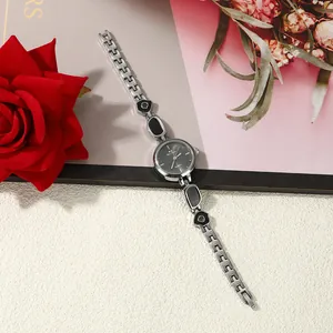 Detailed view of women's silver bracelet watch with black irregular enamel accents