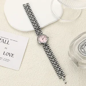 Detail view of retro ladies quartz watch with pink dial and silver chain strap