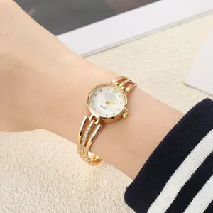 Close-up of a gold-toned women's quartz watch with rhinestone-encrusted steel band