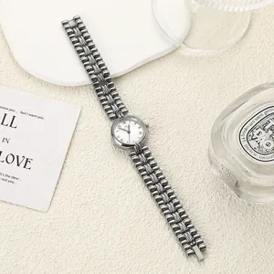 Elegant retro round quartz watch with refined gunmetal chain strap in studio setting