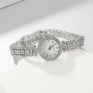 Nahaufnahme der luxuriösen silbernen Damenarmbanduhr mit Strasssteinen und Perlenarmband