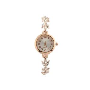 Detailed macro shot of a rose gold clover bracelet watch with sparkling rhinestones.