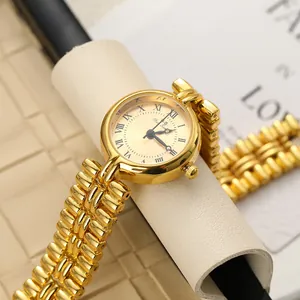 Close-up detail of luxury gold vintage quartz watch featuring Roman numerals and chain strap
