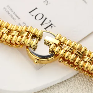 Detailed macro shot of the polished gold chain bracelet and back of a quartz watch