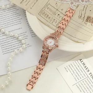 Détail d'une montre femme en or rose ornée de strass et de chiffres romains
