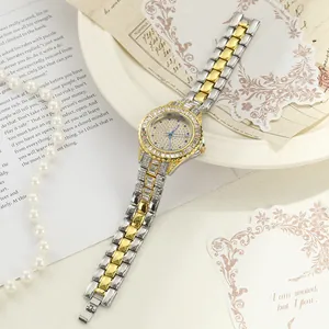 Close-up of iced-out women's quartz watch in gold and silver tone alloy strap.