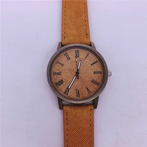 Close-up of vintage bronze quartz watch with denim texture strap and Roman numerals