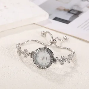 Detailansicht der silbernen Damenarmbanduhr mit Blumenanhängern und Strasssteinen