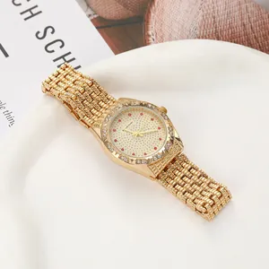 Detailed view of luxury gold quartz watch featuring red diamond accents and crystal-set dial