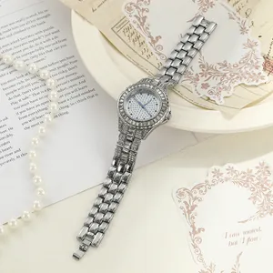 Detailed close-up of a silver-tone iced-out women's watch with rhinestone bezel