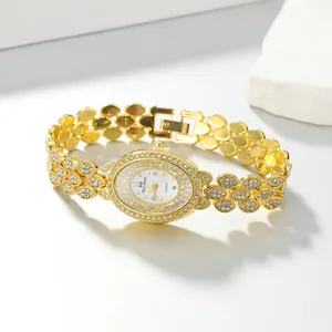 Close-up of elegant gold oval quartz bracelet watch with sparkling rhinestone inlay