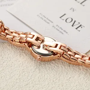 Macro view of luxury rose gold ladies quartz watch with H-shaped bracelet links.