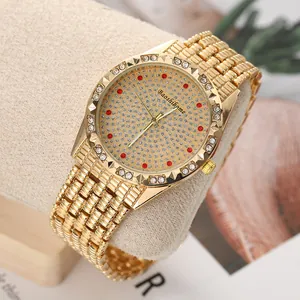 Close-up of luxury gold quartz watch with iced out dial and red diamond hour markers.