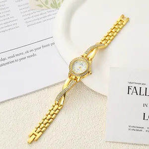 Elegant gold-tone quartz watch with rhinestone-encrusted crisscross band on white background.