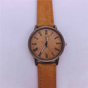 Close-up of a vintage bronze quartz watch with a unique yellow denim texture strap.
