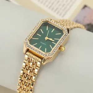 Close-up of elegant women's rectangular quartz watch with green dial and gold strap