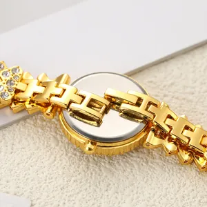 Vue macro montrant le bracelet doré à maillons en H et le dos de montre poli détail