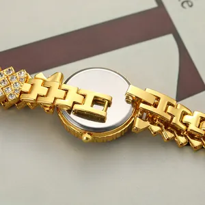 Close-up of elegant gold women's quartz watch with rhinestone bracelet detail