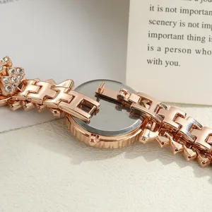 Close-up of rose gold watch case back and sparkling diamond-encrusted metal band.