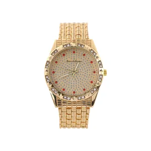 Close-up detail of a gold quartz watch with a diamond-encrusted dial and red accents