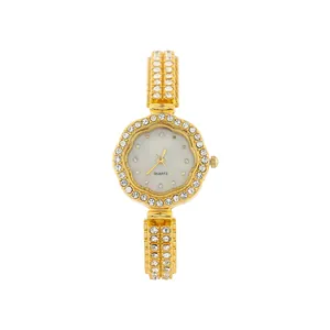Macro view of flower-shaped rhinestone bezel on elegant gold women's quartz watch