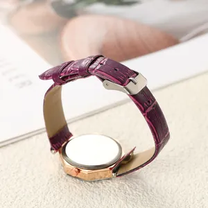 Detail eines lilafarbenen Kroko-Lederarmbandes und einer roségoldenen Quarzuhr