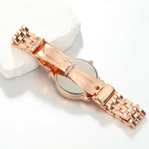 Macro view showing the polished rose gold alloy strap and folding clasp of a women's watch.