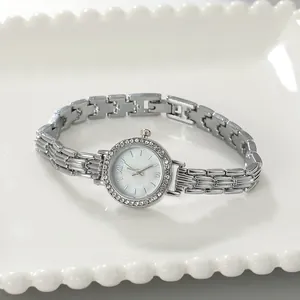 Elegant silver alloy women's bracelet watch featuring a rhinestone bezel and white dial