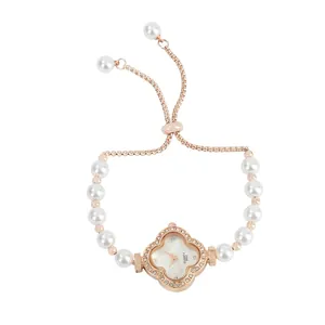Macro view of the sparkling clover-shaped watch face with delicate pearl bracelet strap