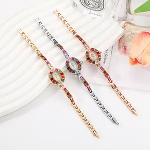 Montre élégante pour femme avec lunette sertie de pierres colorées et bracelet en métal