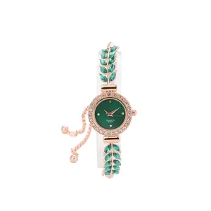 Detailed close-up of rose gold women's quartz watch with green leaf crystal bracelet.