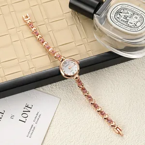 Elegant rose gold women's bracelet watch featuring pink crystal accents and heart-shaped links