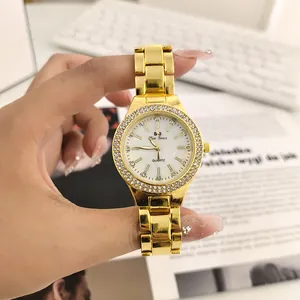 Dettaglio del quadrante dell'orologio al quarzo dorato con strass e cinturino.
