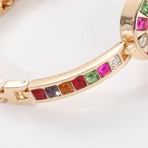 Montre femme tendance en alliage doré avec pierres précieuses multicolores incrustées