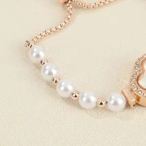 Macro close-up of elegant pearl bracelet watch featuring floral rhinestone detailing