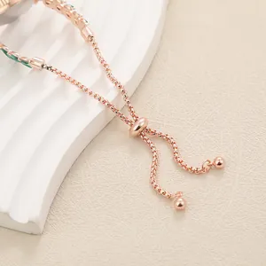 Detailed view of rose gold watch chain featuring an adjustable slider and green leaf design