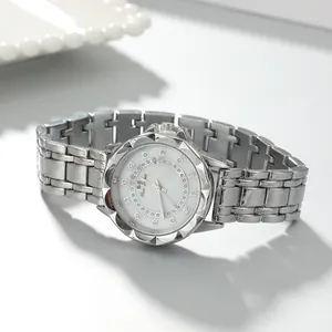 Detailed macro view of elegant silver steel band ladies watch with rhinestone-encrusted dial