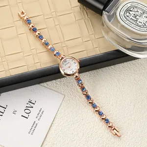 Elegant rose gold bracelet watch featuring blue crystals and heart-shaped links detail
