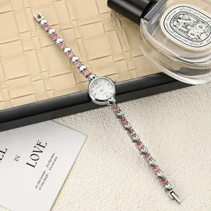 Elegant silver-toned women's bracelet watch with heart-shaped links and pink crystals