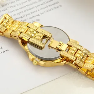 Detailed close-up of gold iced-out women's watch back case and luxury metal link band
