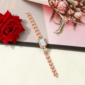 Close-up of elegant rose gold ladies watch with square light blue dial and link bracelet