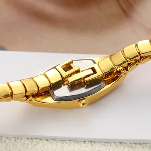 Close-up detail of a vintage-style gold women's watch with a unique interlocking clasp