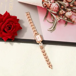 Close-up of elegant rose gold square quartz watch with textured bezel and chain strap