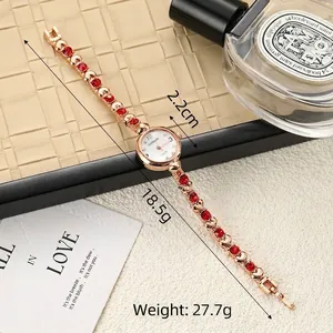 Elegant ladies gold-tone bracelet watch featuring red rhinestones and clear dial details