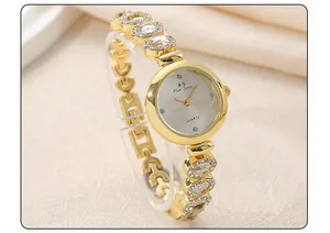 Detailed close-up of a luxury gold women's bracelet watch with crystal diamond link accents