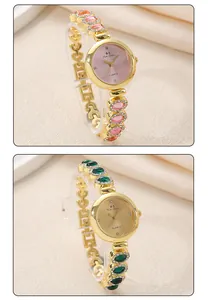 Detail view of luxury gold-tone women's bracelet watches with pink and green crystals