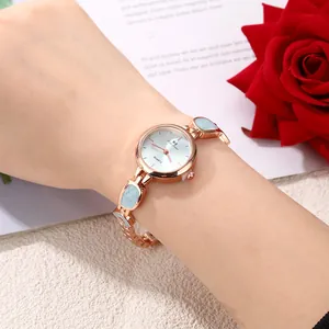 Close-up view of elegant rose gold women's bracelet watch featuring light blue enamel details