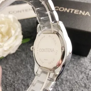 Macro view of polished stainless steel watch back with brand engraving and serial number