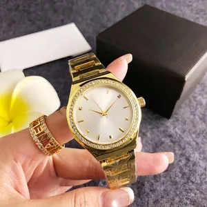 Gold-toned luxury women's watch with rhinestone bezel and white dial on model's hand