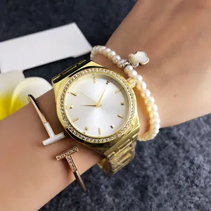 Close-up of elegant gold stainless steel women's watch with crystal bezel and white dial